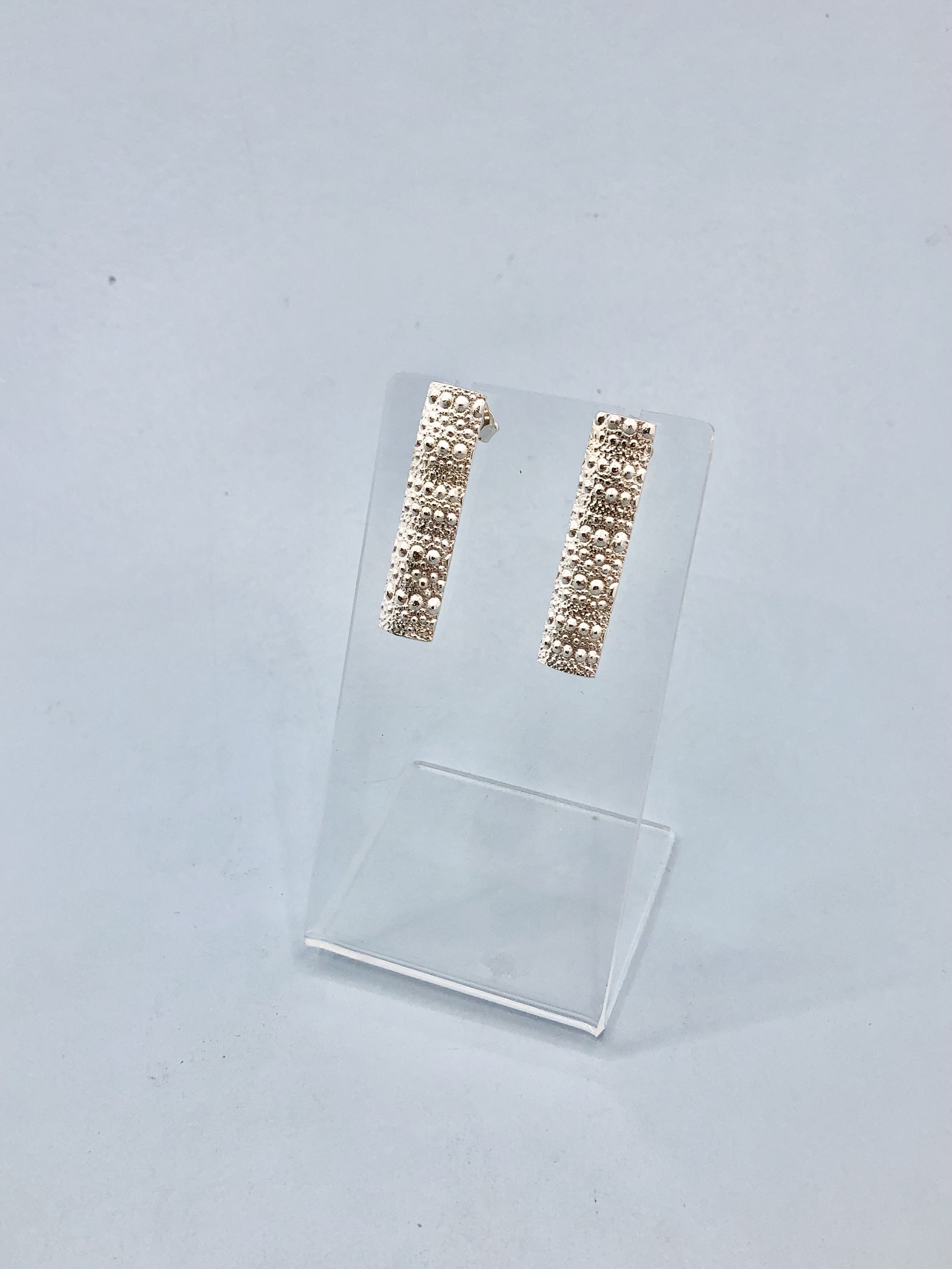 Close-up of long kina textured silver stud earring showing spine detail, 35mm length, handcrafted in New Zealand
