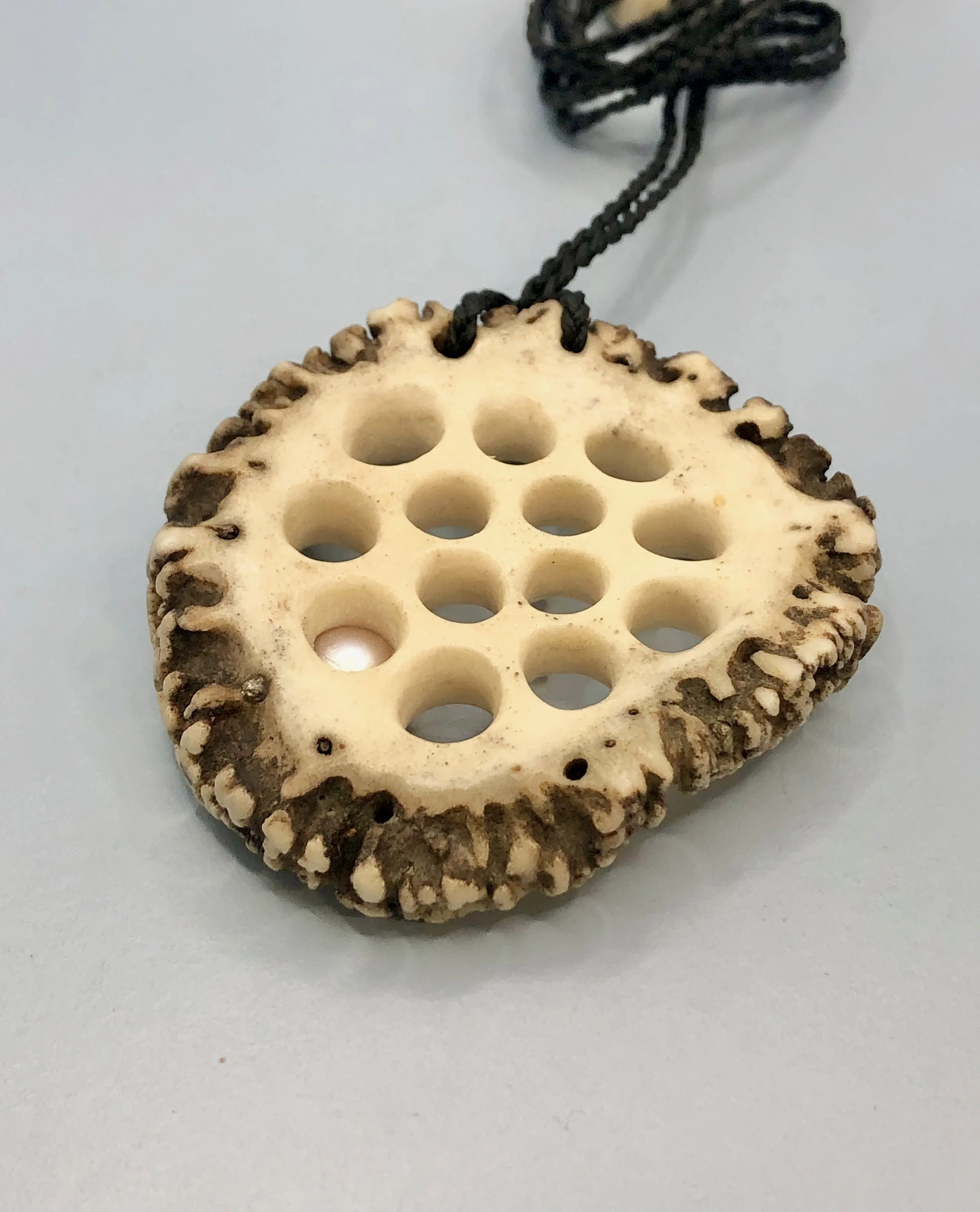 Reverse side of the hand carved lotus root antler and pearl pendant