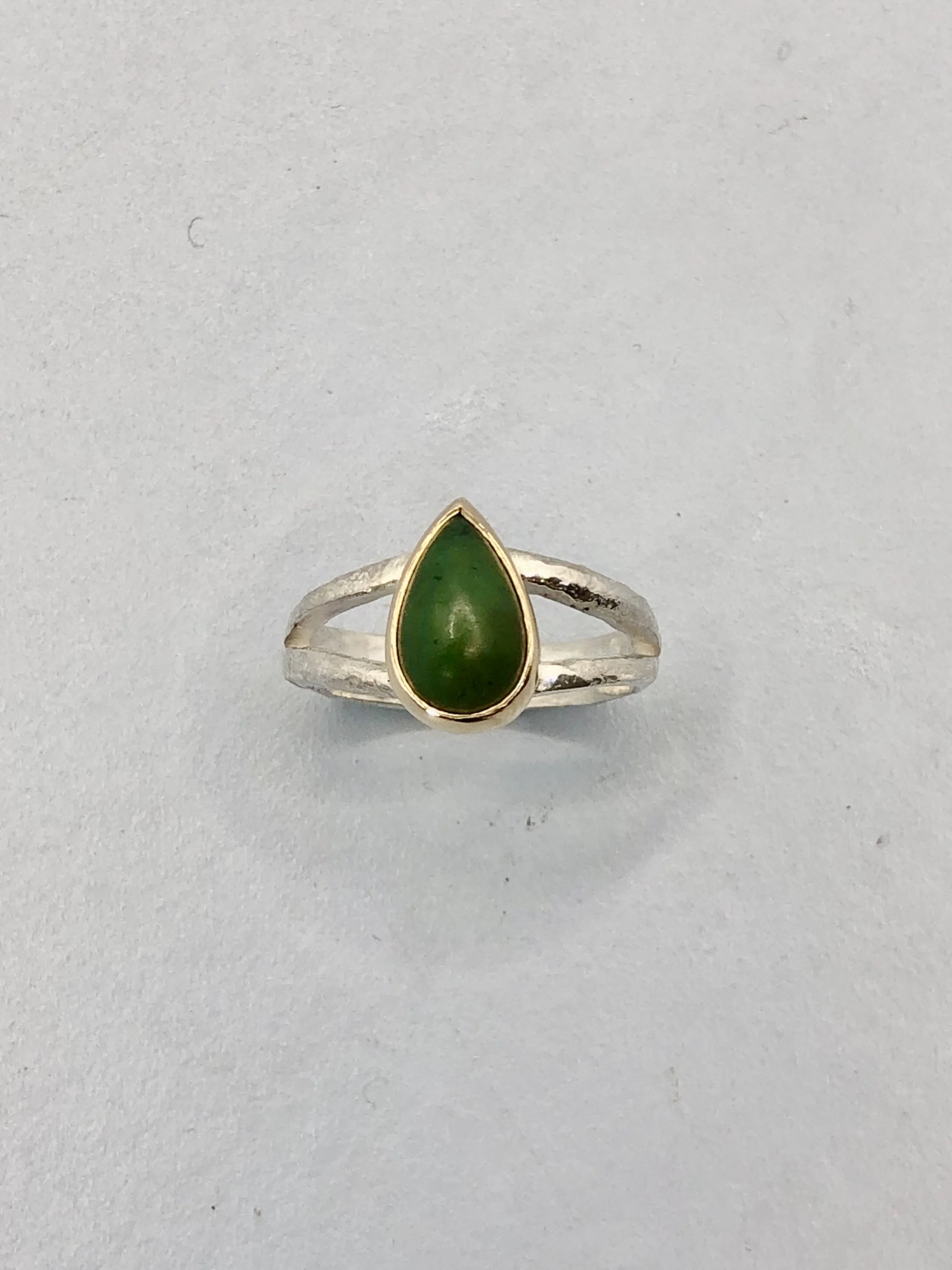 Top view of hand-cut NZ greenstone teardrop ring showing pounamu colour and gold setting detail
