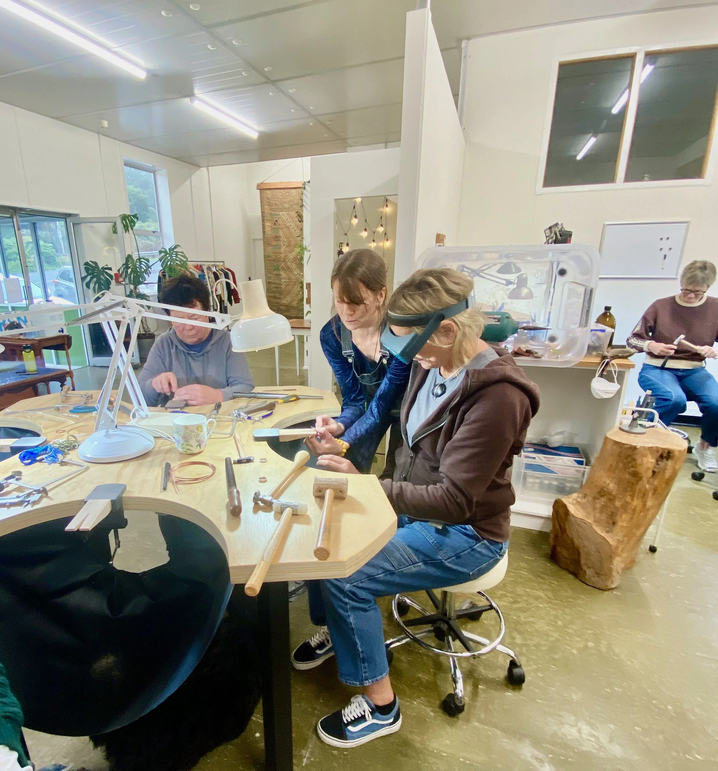Workshop class in action, overseeing a student making a ring.