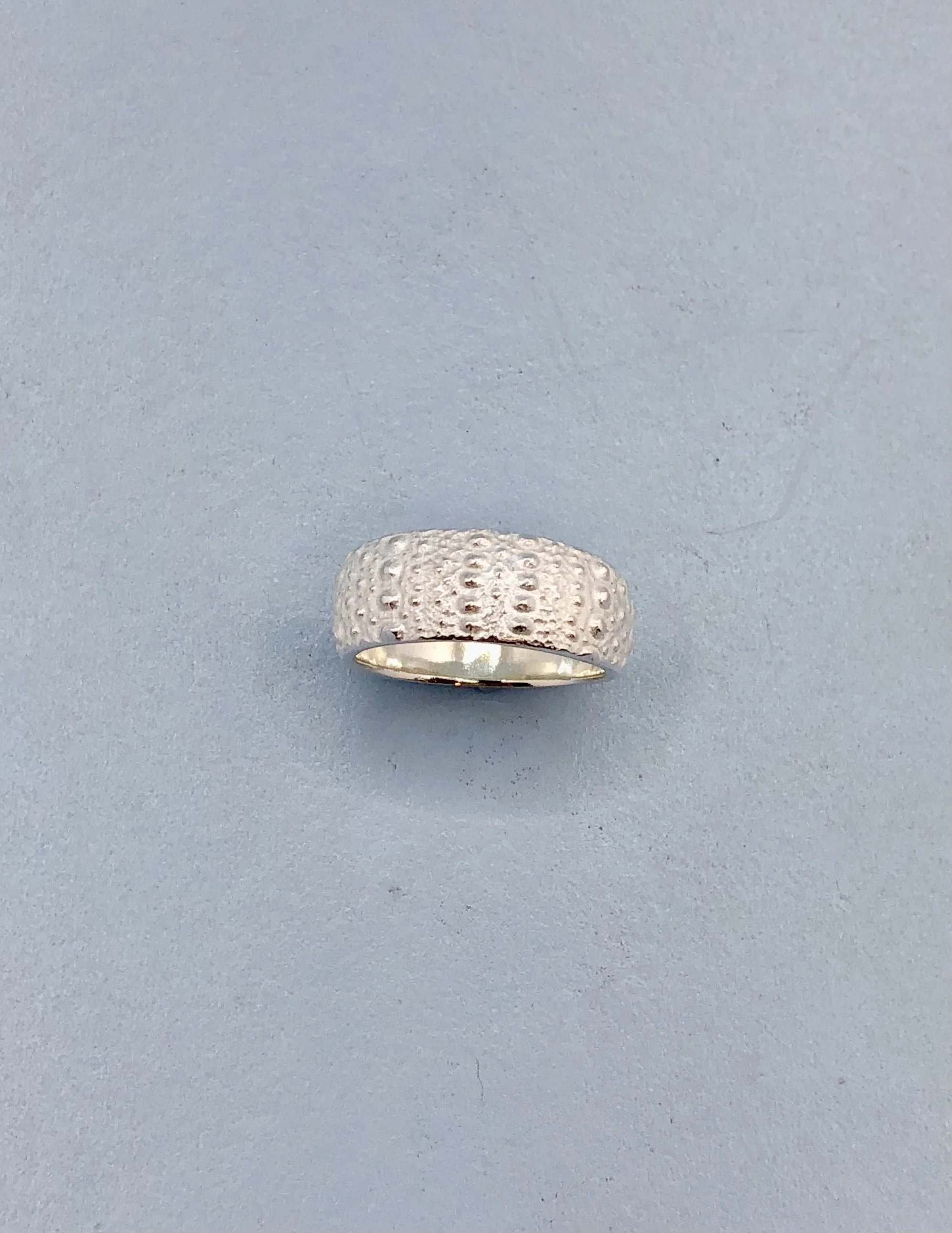 Top view of kina sterling silver ring showing 8mm wide tapered face and texture