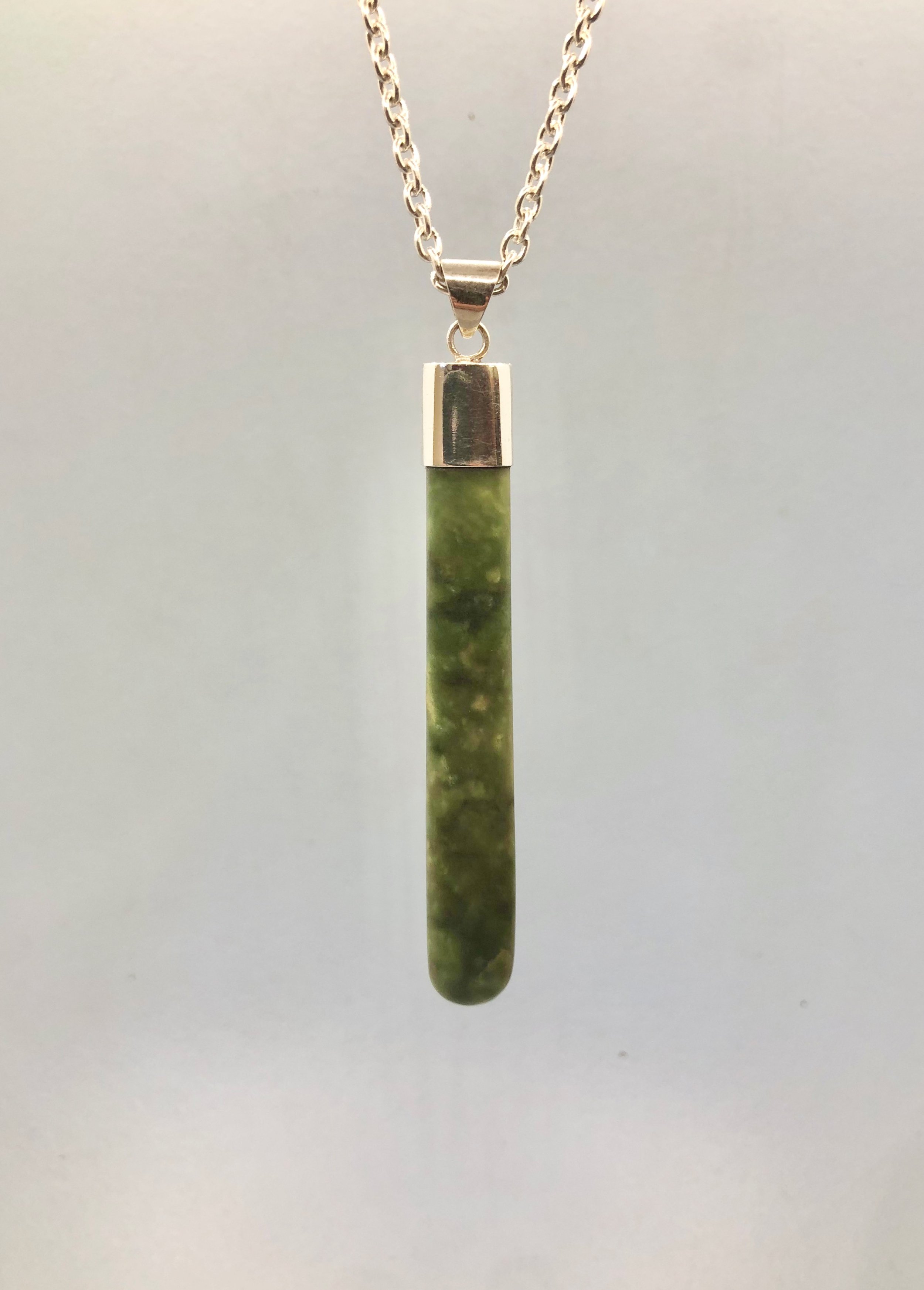 NZ Pounamu pendant shown hanging from 925 cable chain, reverse side.