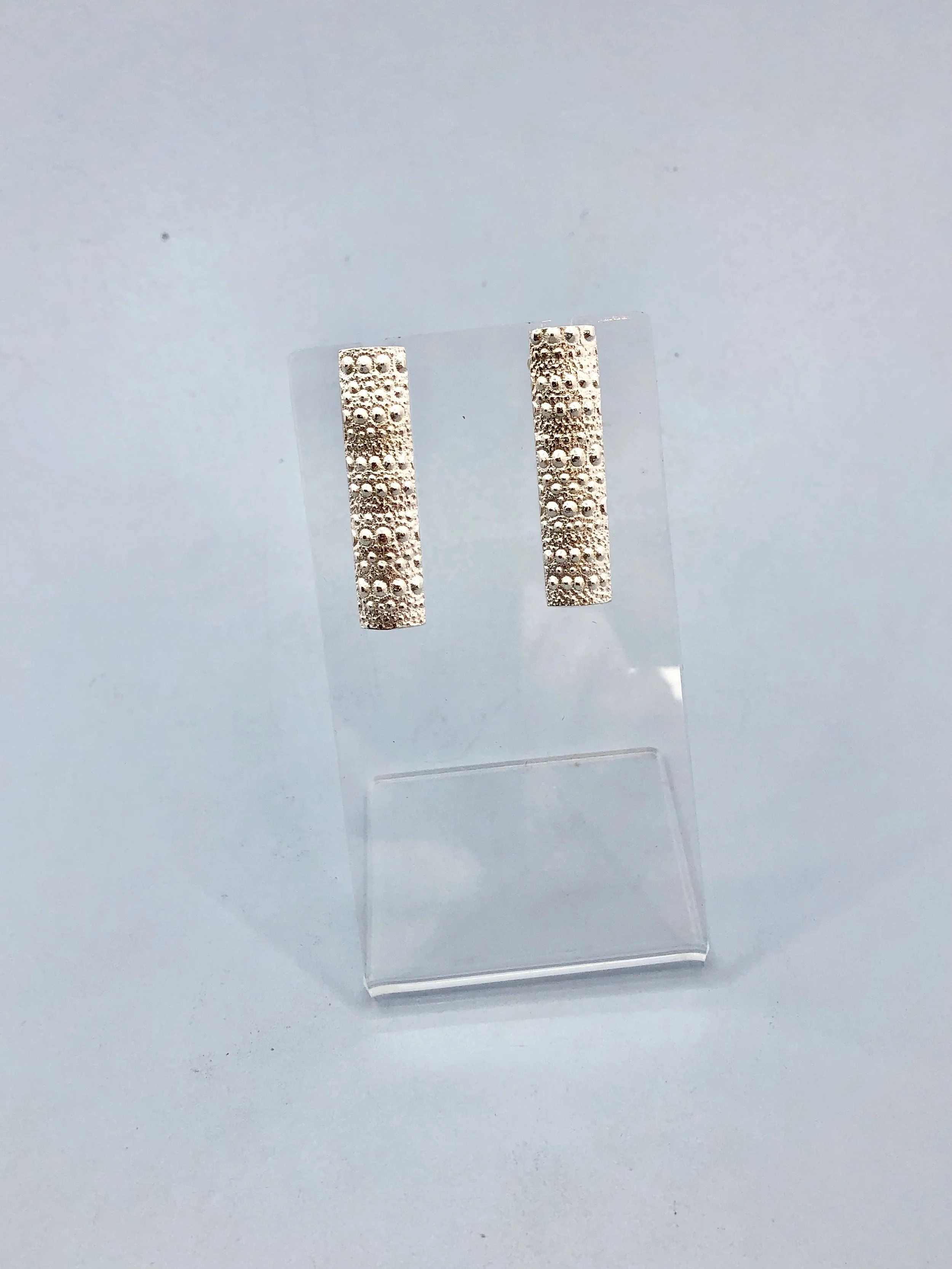 Long sterling silver kina stud earrings with sea urchin texture and butterfly backs. Rachel Lambert Jewellery