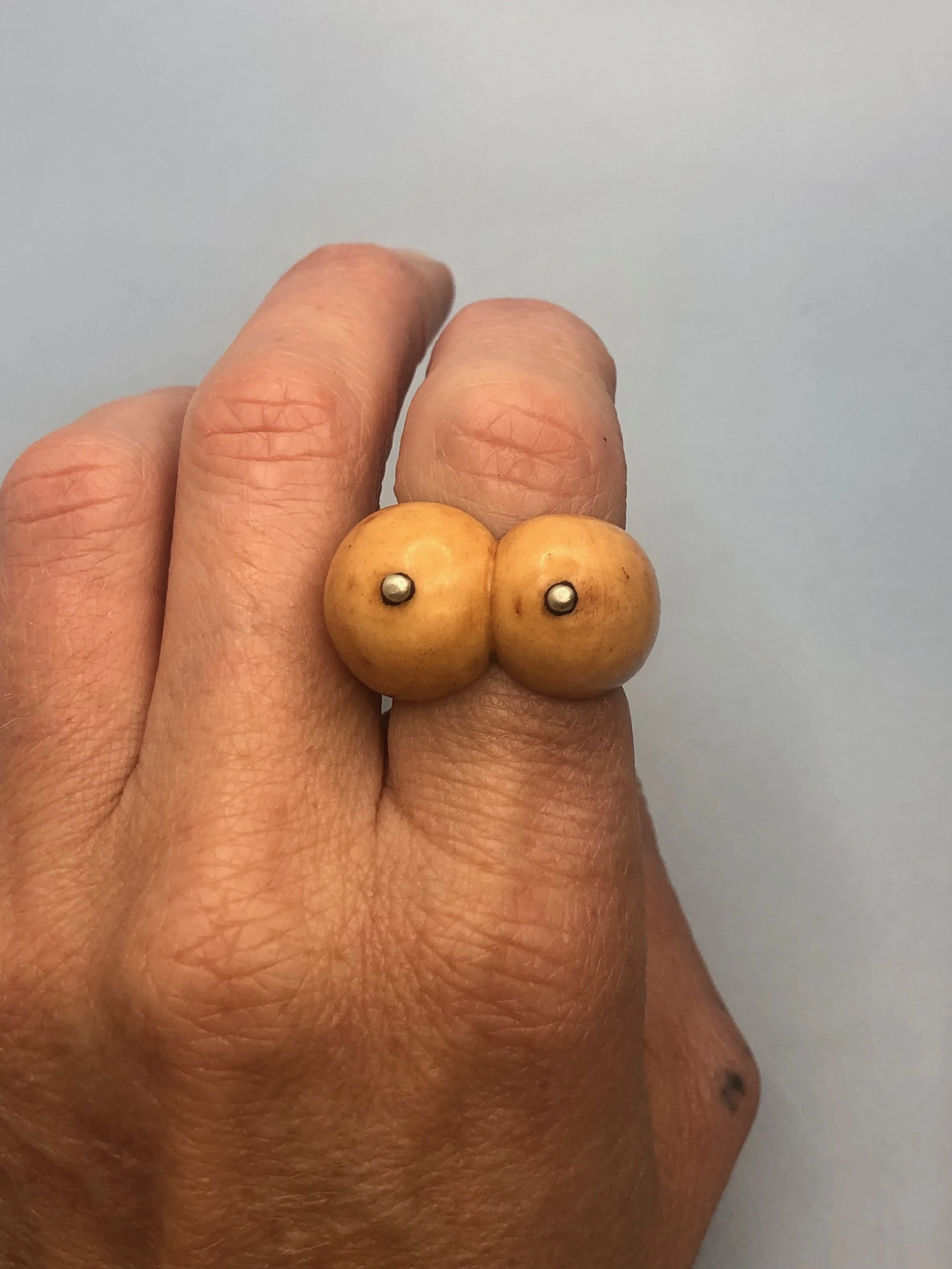 Top view of bone boobs ring being worn on finger