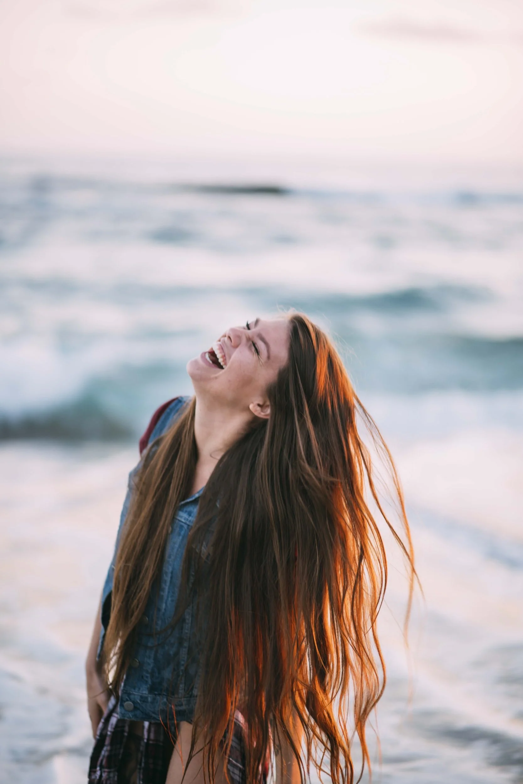 a woman laughing on the beach in florida, online therapy, online counseling