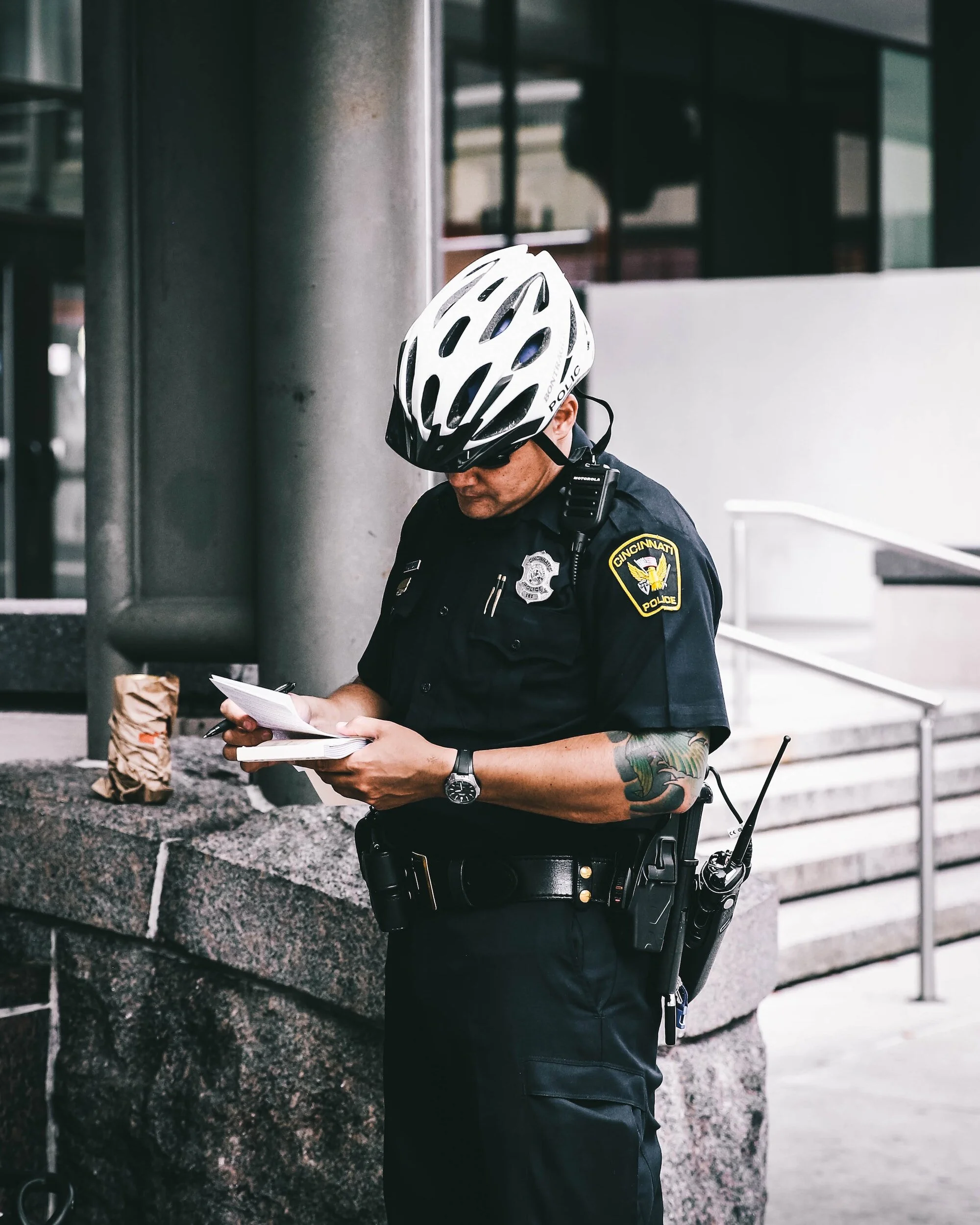 a policeman wearing a bike helmet giving someone a ticket, therapists for police officers, counseling for first responders