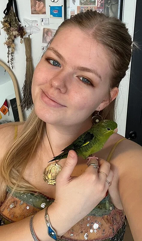 Friendly Five Paws team member named Kate holding a pet bird