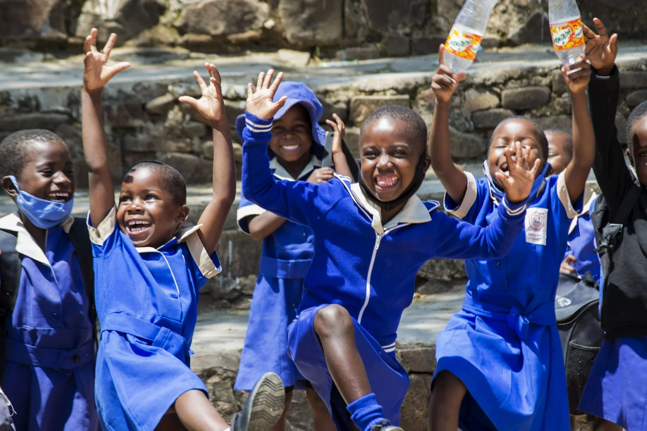 Skolebarn i Zimbabwe smiler og danser