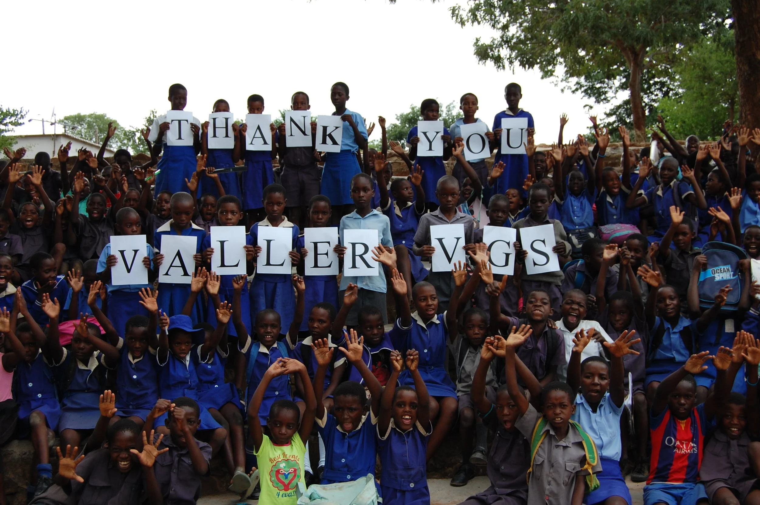 Skolebarn i Zimbabwe holder opp bokstaver med takk til Valler VGS.