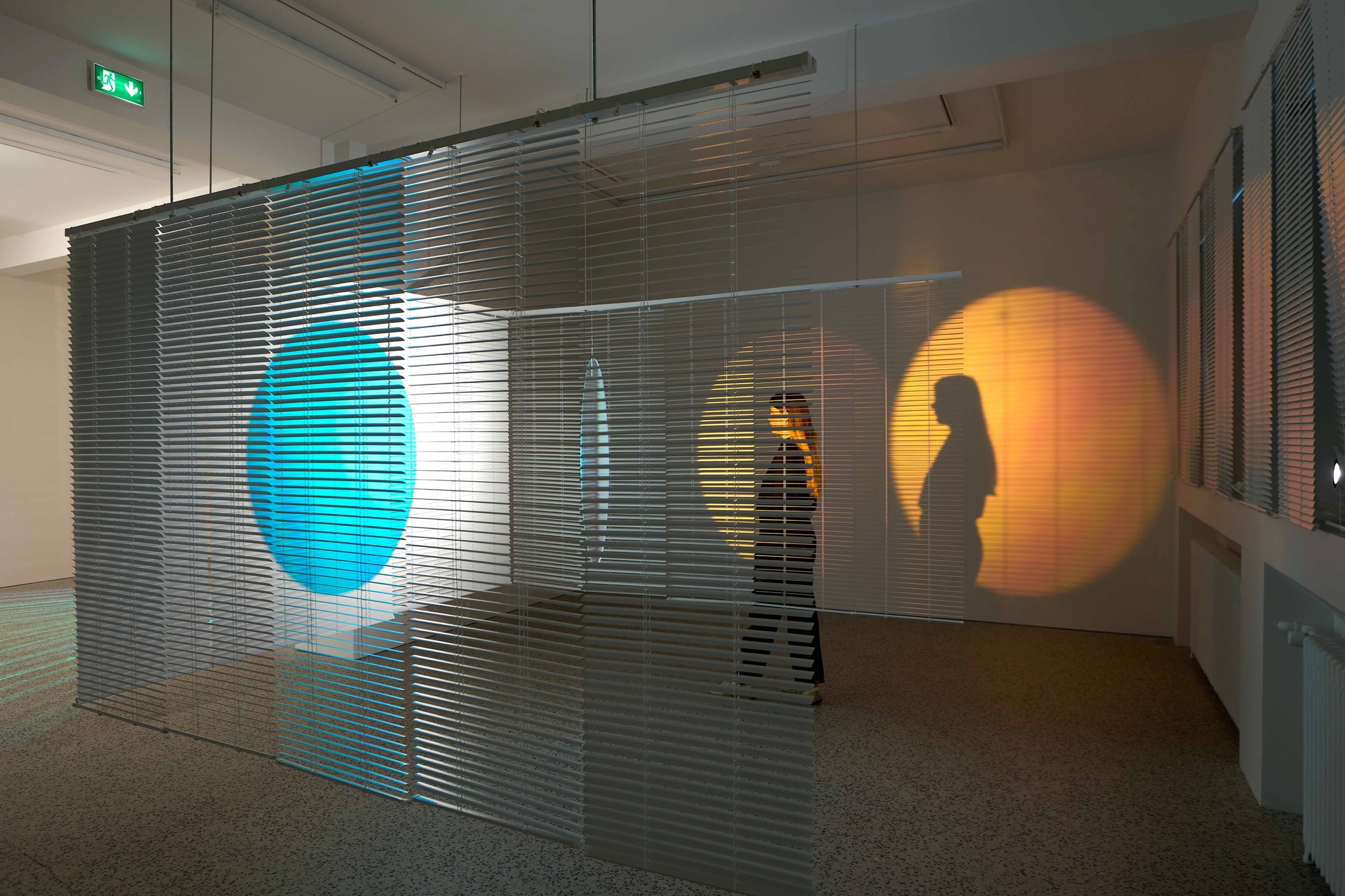 Everyday
2026
Installation with venetian blinds, acrylic glass, dichroic film, spotlight, motor.

Currently on view @bergcontemporary 🌀

In Everyday, we encounter the travels of a blue circle within a space made out of aluminum blinds. The circle is