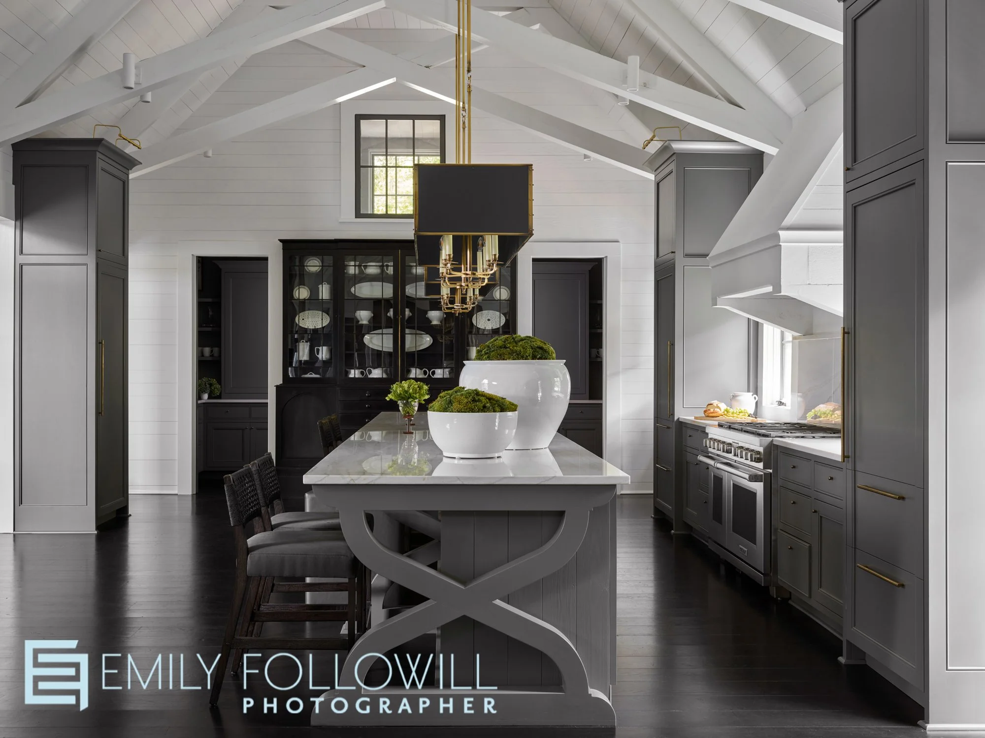 large modern grey and white kitchen with white beams int eh lofted ceiling. Detailed woodwork in the end of the kitchen island. Designed by Susan Ferrier in Lake Martin Alabama. 