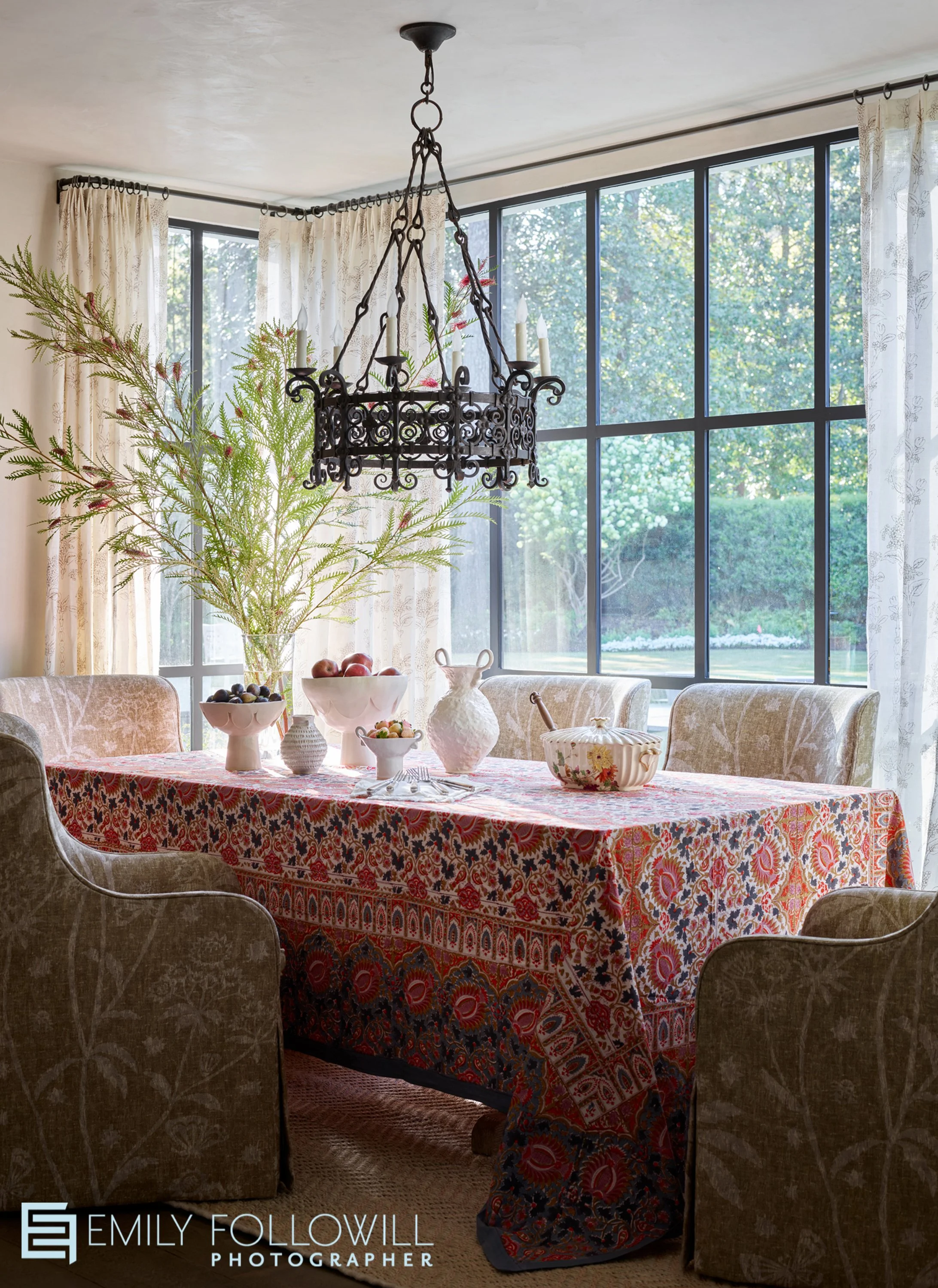 breakfast room with a patterned tablecloth, set in floor to ceiling windows, with an iron light fixture. Located in Atlanta Ga