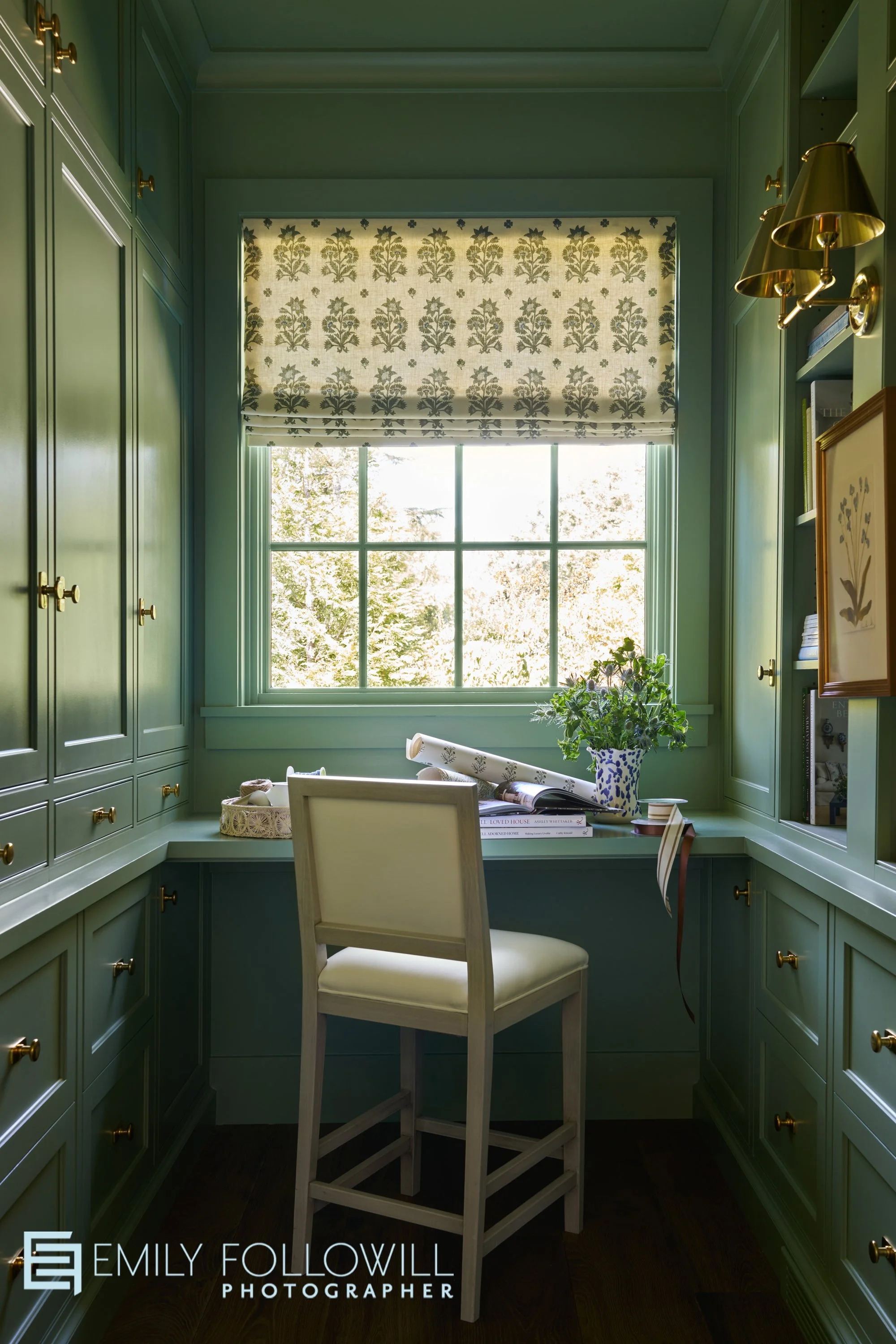Muted green office with book shelves and a gift wrapping station. Designed by Virginia Nocharli