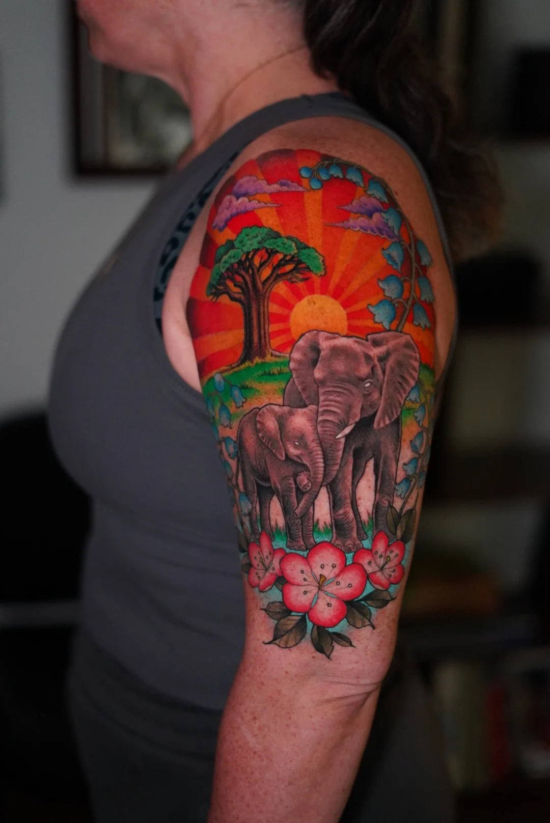 Colorful elephants with flowers and a sunset tattoo on a womans arm-Sacramento tattoo artist01.JPG