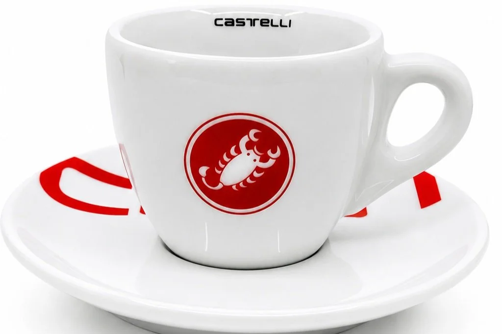 Kaffeetasse mit Castelli-Logo und rotem Design-Element auf weißem Untergrund, Produktfotografie