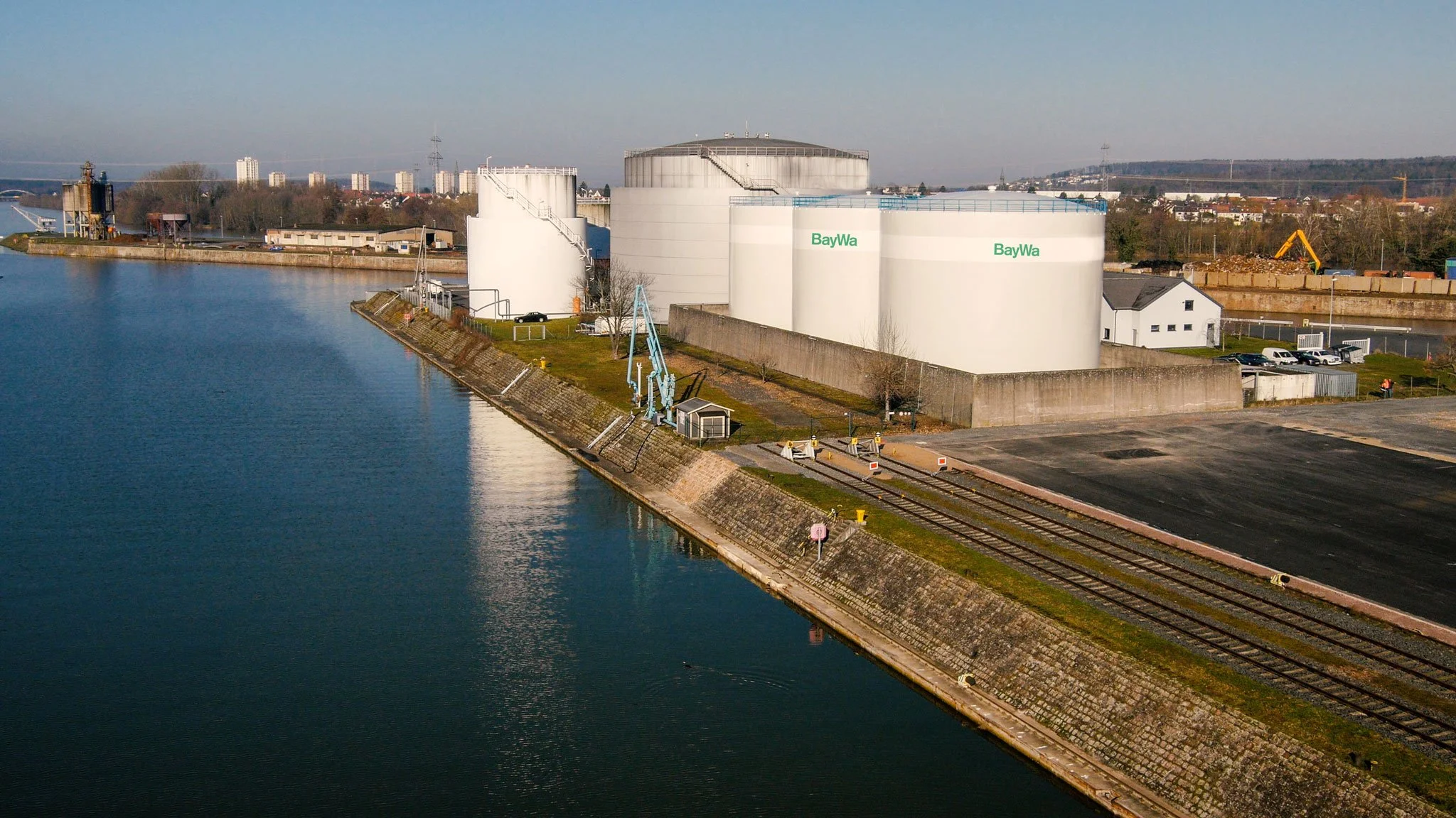 Industrielle Produktionsanlage mit Lagerhallen am Wasser, großformatige Infrastruktur-Fotografie