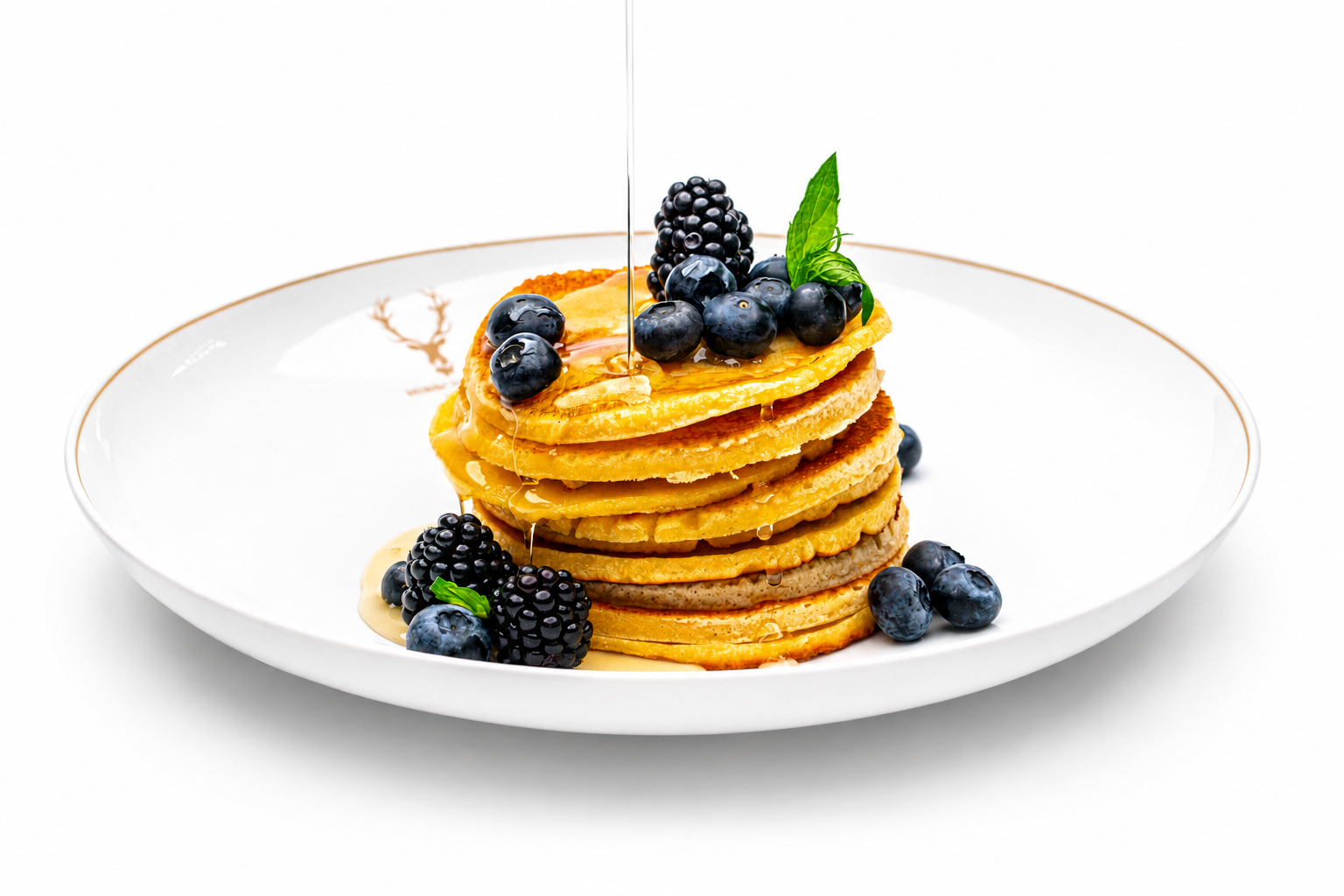Pancakes mit Beeren auf weißem Porzellanteller, Foodfotografie mit professionellem Licht
