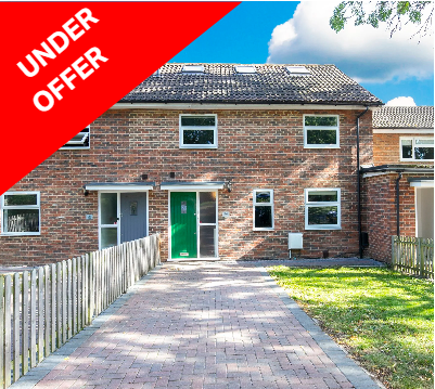 Brick house with a green front door, small windows, a paved driveway, a wooden fence on the left, and a lawn on the right, under a blue sky with clouds, with an 'Under Offer' banner in red and white.