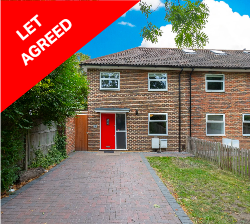 Front view of a two-story brick house with a red door, a small front yard, and a paved driveway, with a red banner in the corner that says 'LET AGREED'.