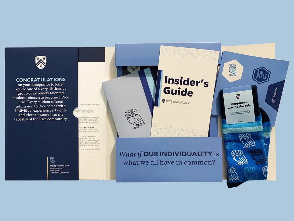 Contents of the Admit Packet include the acceptance letter, certificate and swag items. Swag items are notebook, an insider's guide, socks, stickers and a social media banner. 
