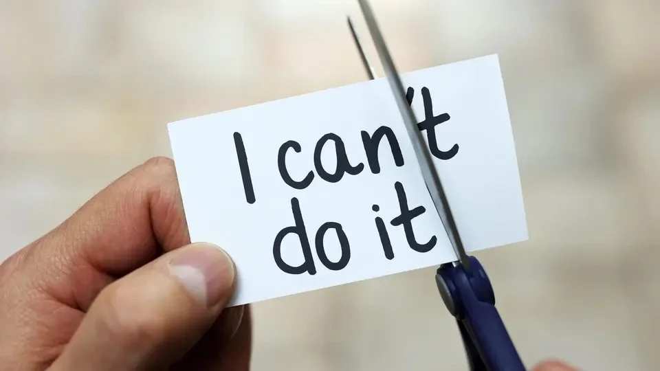 Hand cutting "I can't do it" card with scissors