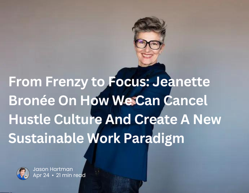 Smiling woman with short hair and glasses wearing a dark blazer against a plain background, featured in an article about sustainable work culture by Jason Hartman.