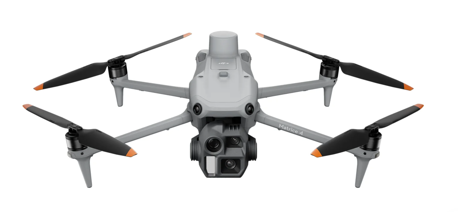 A gray quadcopter drone with four propellers and a camera mounted on the front.
