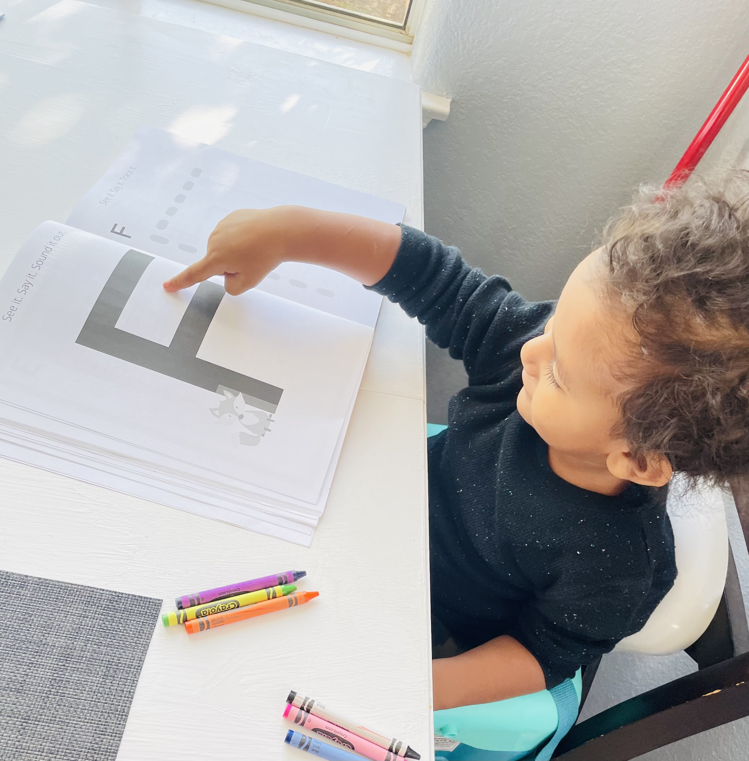 Toddler practices the alphabet.