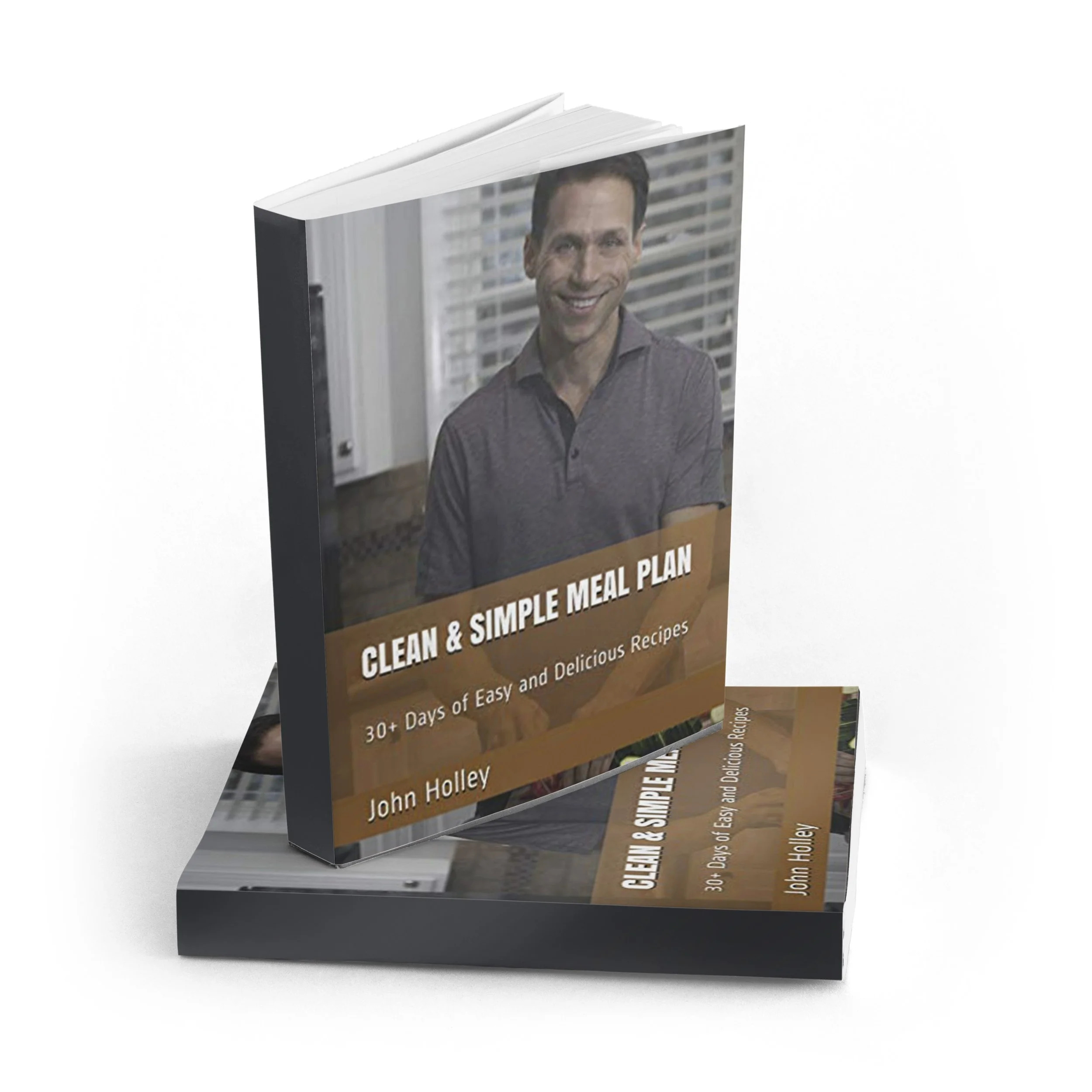Clean & Simple Meal Plan: 30+ Days of Easy and Delicious Recipes book cover, written by John Holley. John stands in a kitchen preparing fresh food.