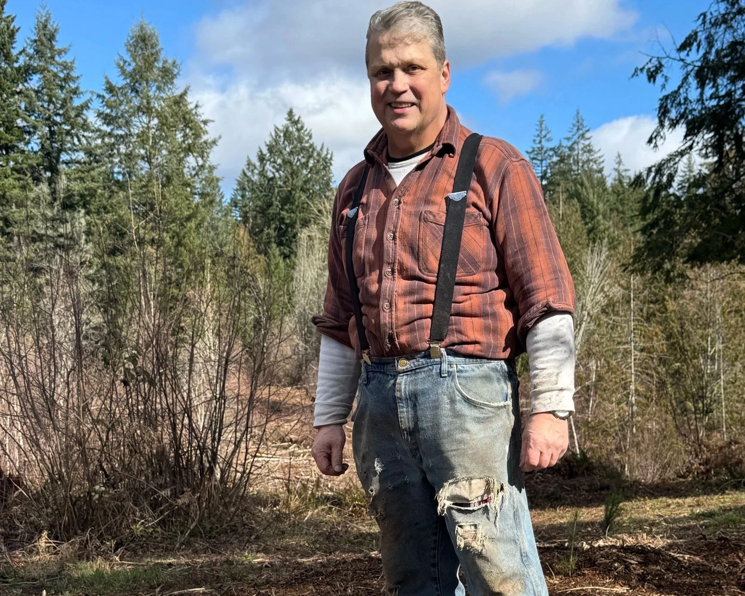  A land steward surveys his forest after restoration work, reflecting the long term commitment to maintaining healthy landscapes. 