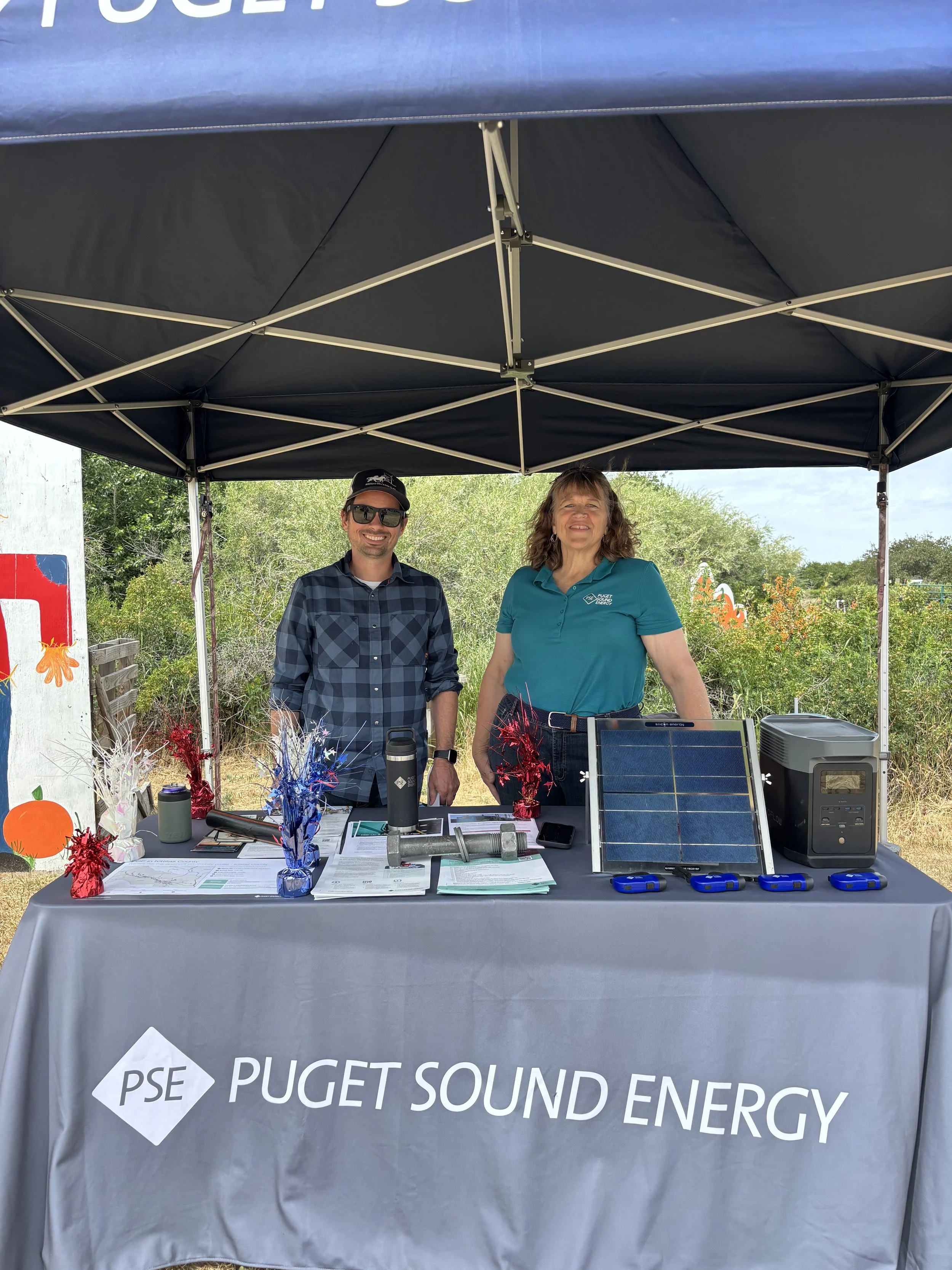  Adam Crawford and Diana Tasker share electrification and energy efficiency resources at the Puget Sound Energy booth during the High Voltage Harvest event. Maia Gutmann. 