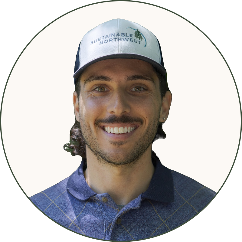 Daniel Wear smiling, wearing a Sustainable Northwest cap and a blue collared shirt