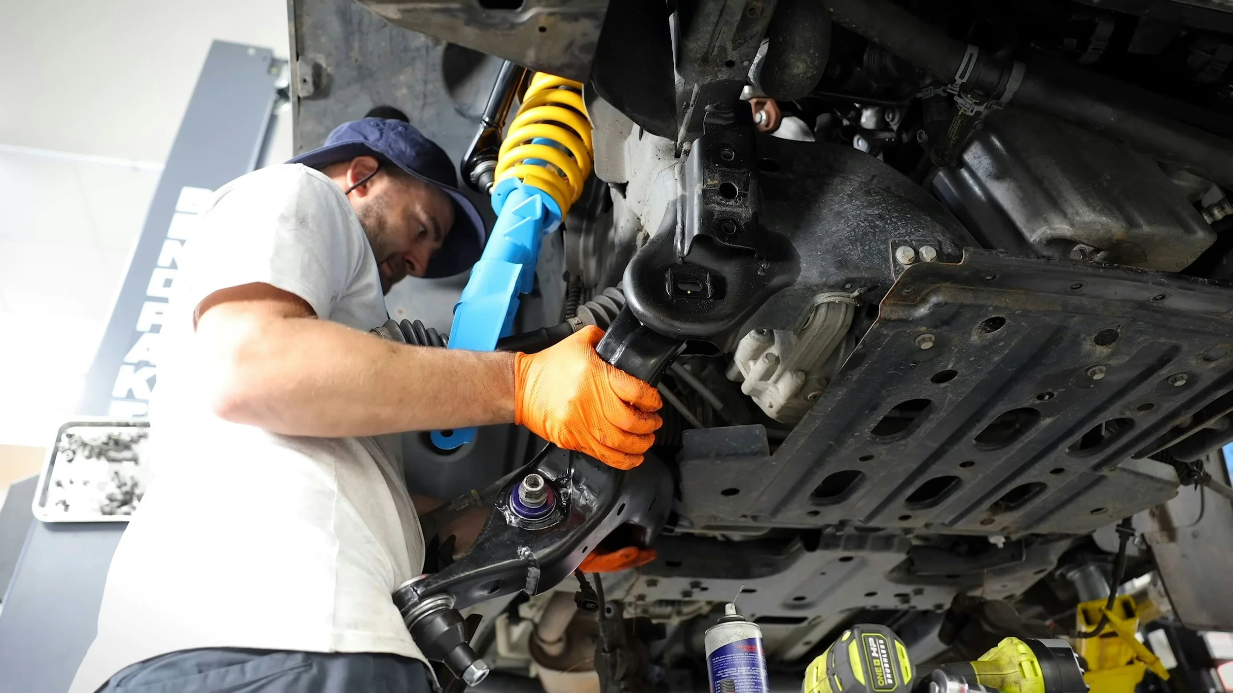 Auto technician working underneath a vehicle