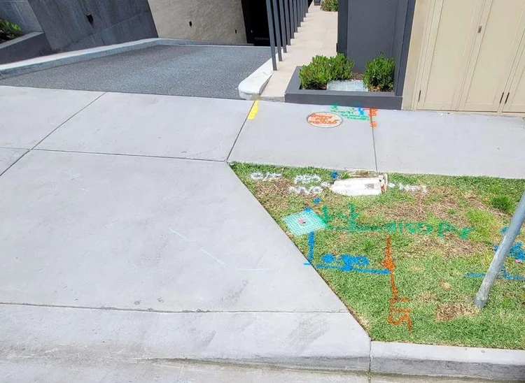 Leak location marked in paint on a path after underground leak detection