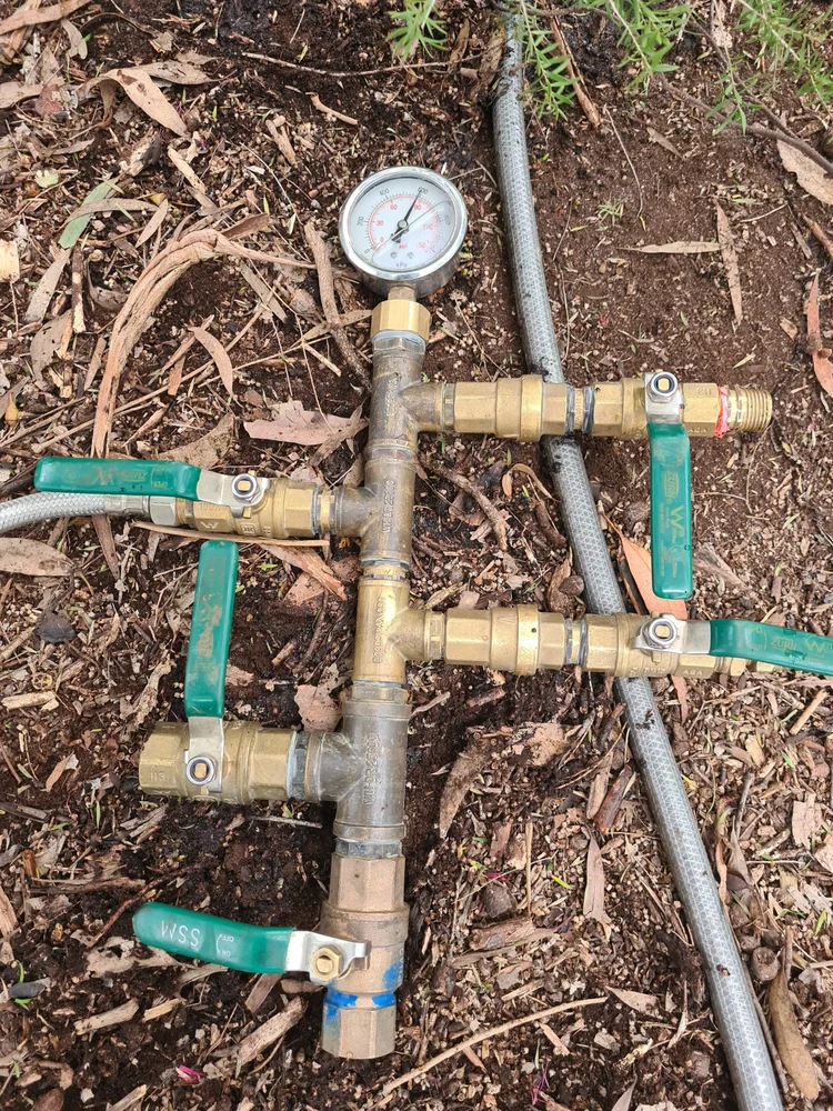 Exposed irrigation pipes in a garden bed after leak detection
