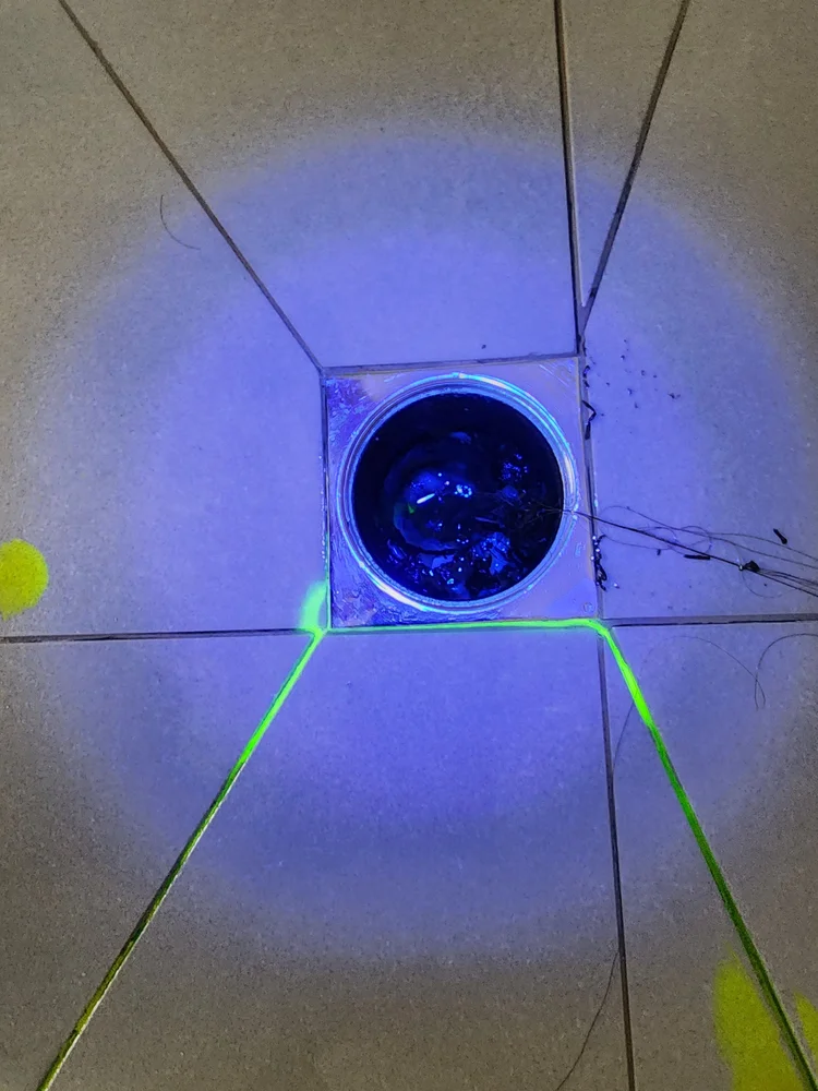 UV tracer dye glowing in a shower floor waste during a leak test
