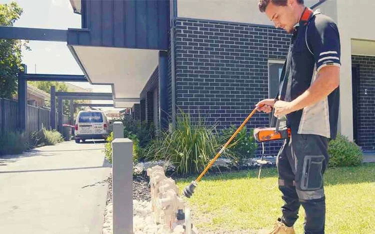 Technician listening for a leak with an acoustic stick on a front path