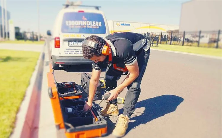 Technician checking a water meter pit for a hidden leak