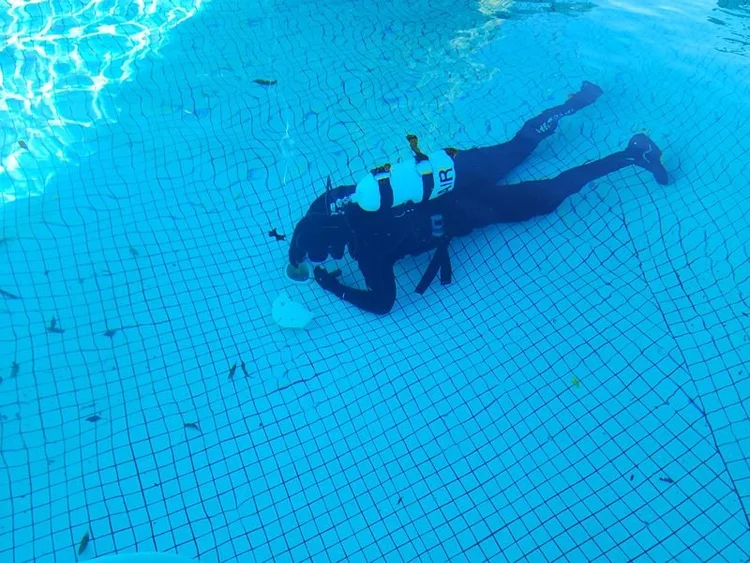 Diver checking a pool floor for leaks