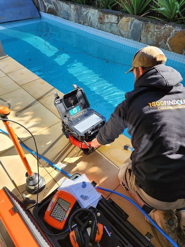 Technician with pressure test equipment at a pool edge