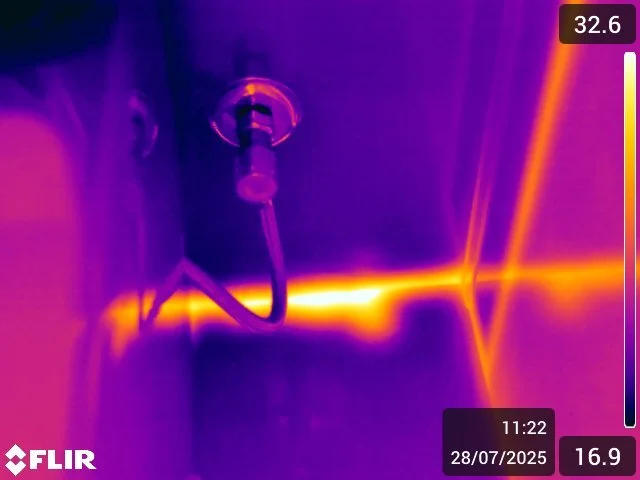 Thermal image of a hot water pipe running inside a wall
