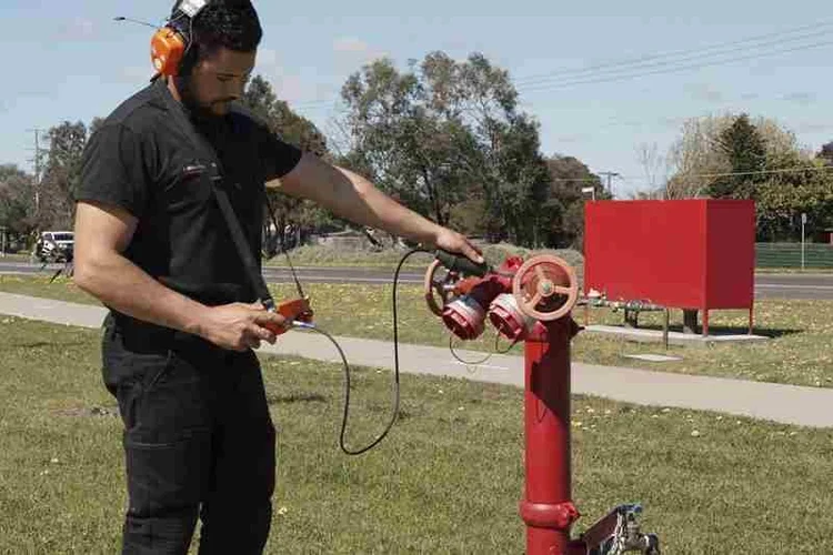 Technician testing a fire hydrant booster for a leak