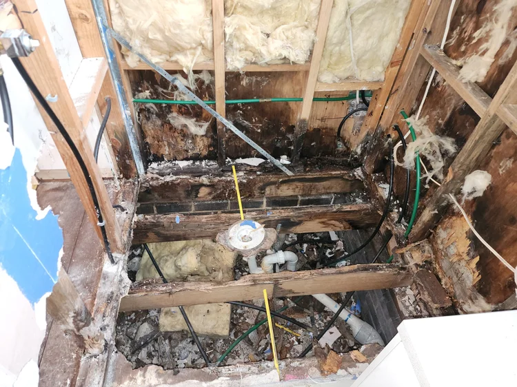 Wall and floor opened at the exact point of a leaking pipe