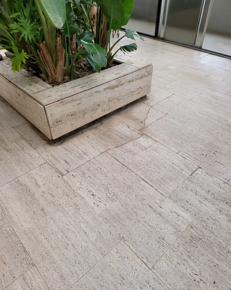 Water stain spreading across floor tiles from a slab leak