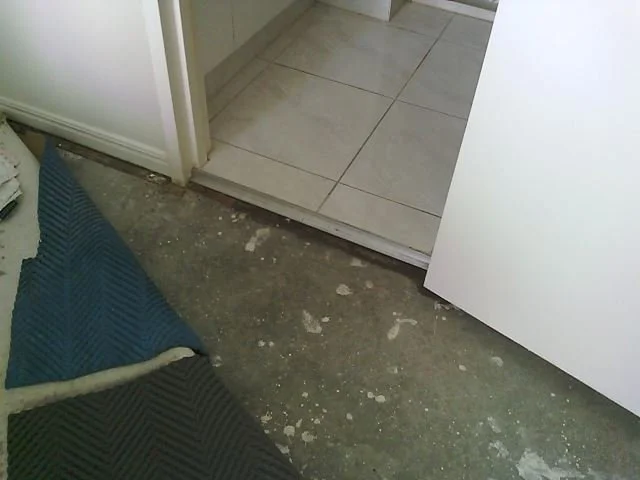 Holes in a 150 mm waste stack pipe causing water damage in a high-rise apartment