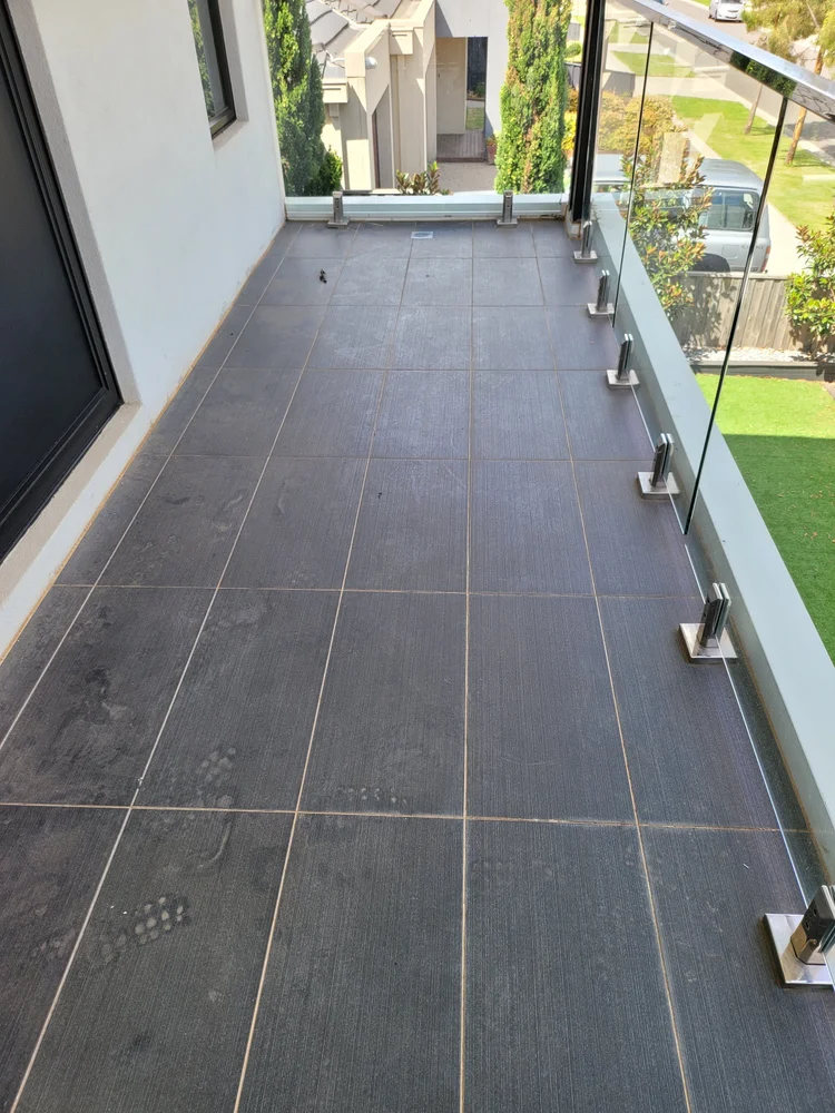 Tiled balcony with a glass balustrade checked for water entry