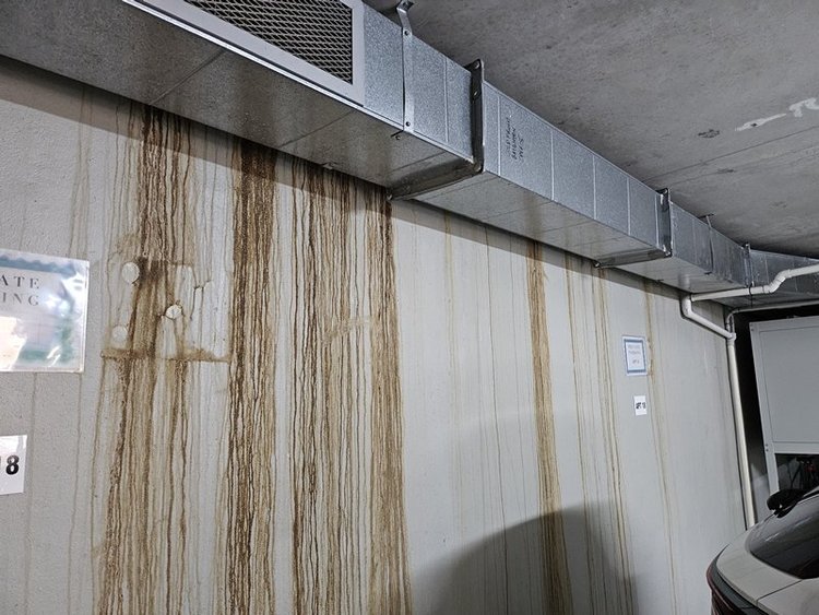 Water stains down a basement car park wall from a hidden leak