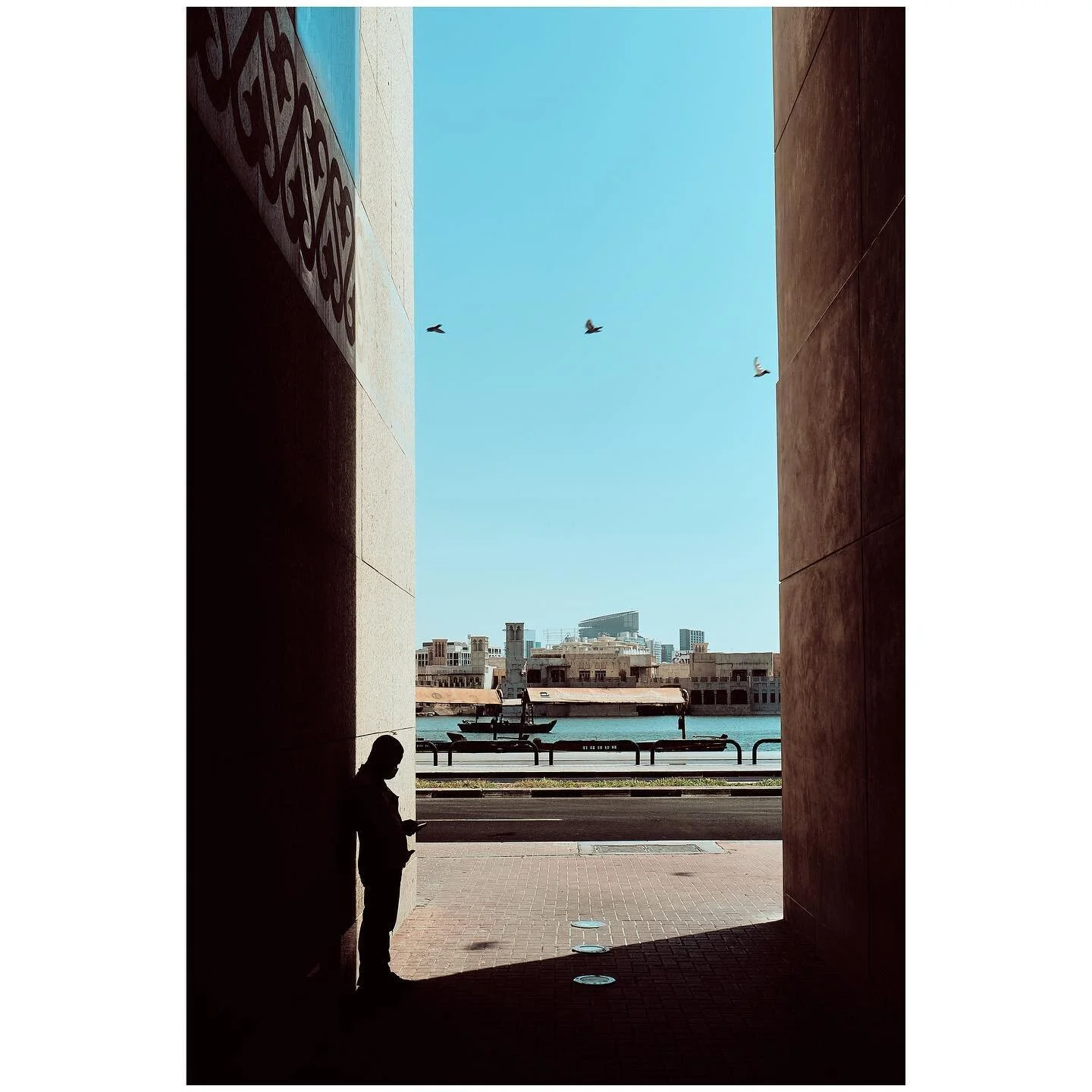Deira birds and the shadow man! 
This shot was taken in Deira. I first spotted the man on the phone in the shadow. The 3 birds were a plus on the 4th photo. Used a polarised filter and processed with Capture One. Fujifilm X-Pro3 with 16mm f1.4. 
-
-
