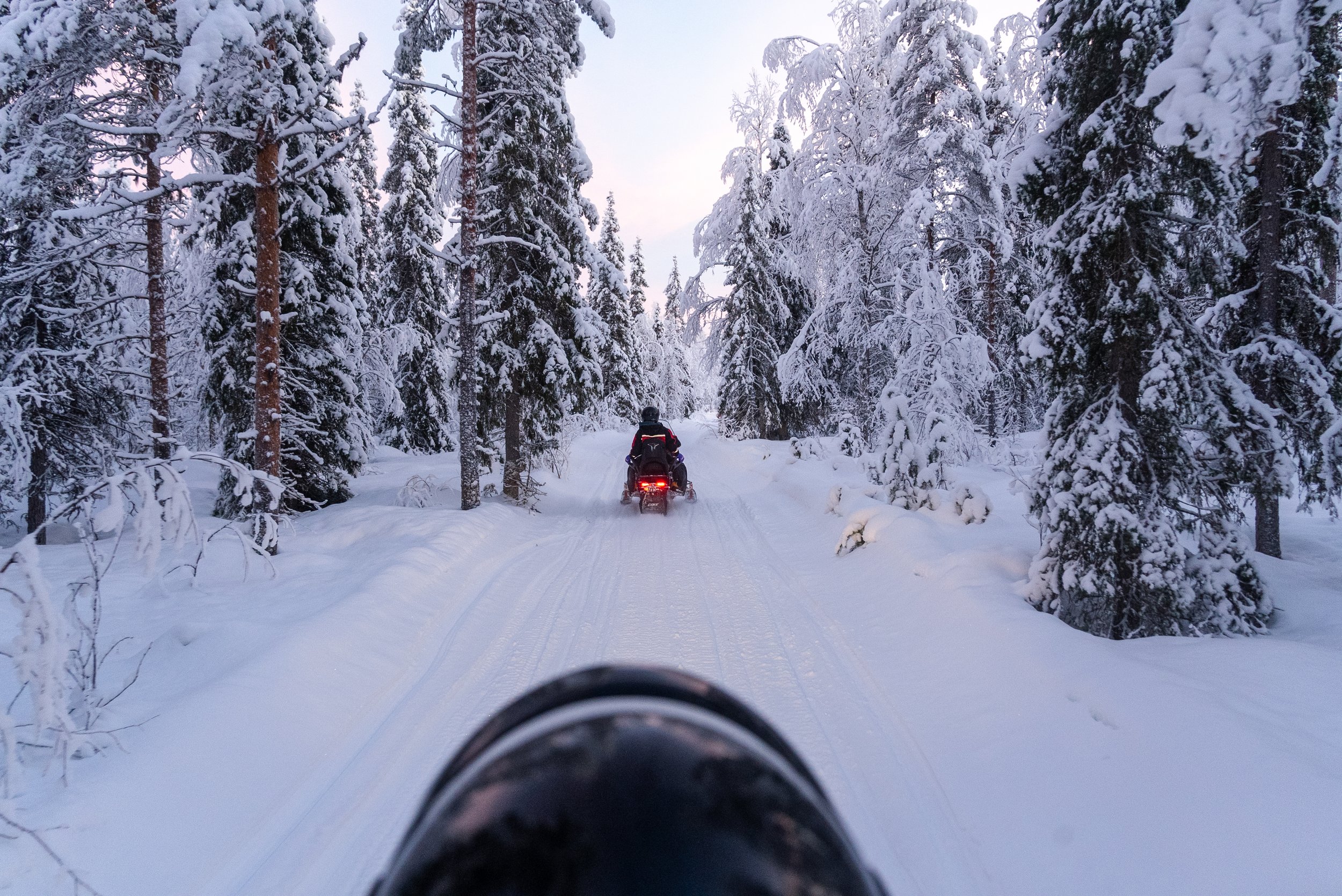 Snowmobiling adventure across frozen landscapes in Luosto, Finnish Lapland