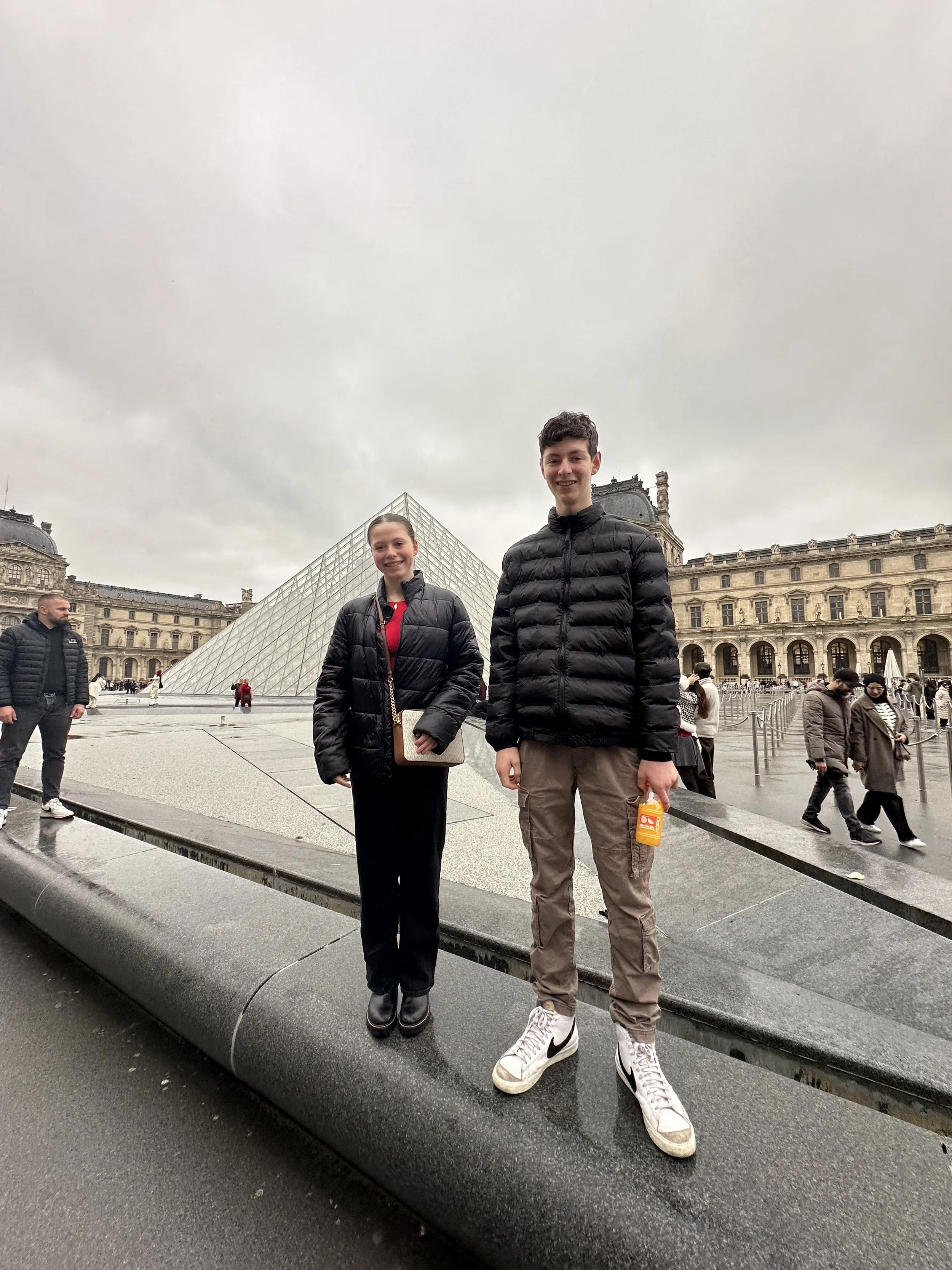 Two American teenageres at the Pyramid at the Louvre in Paris, France